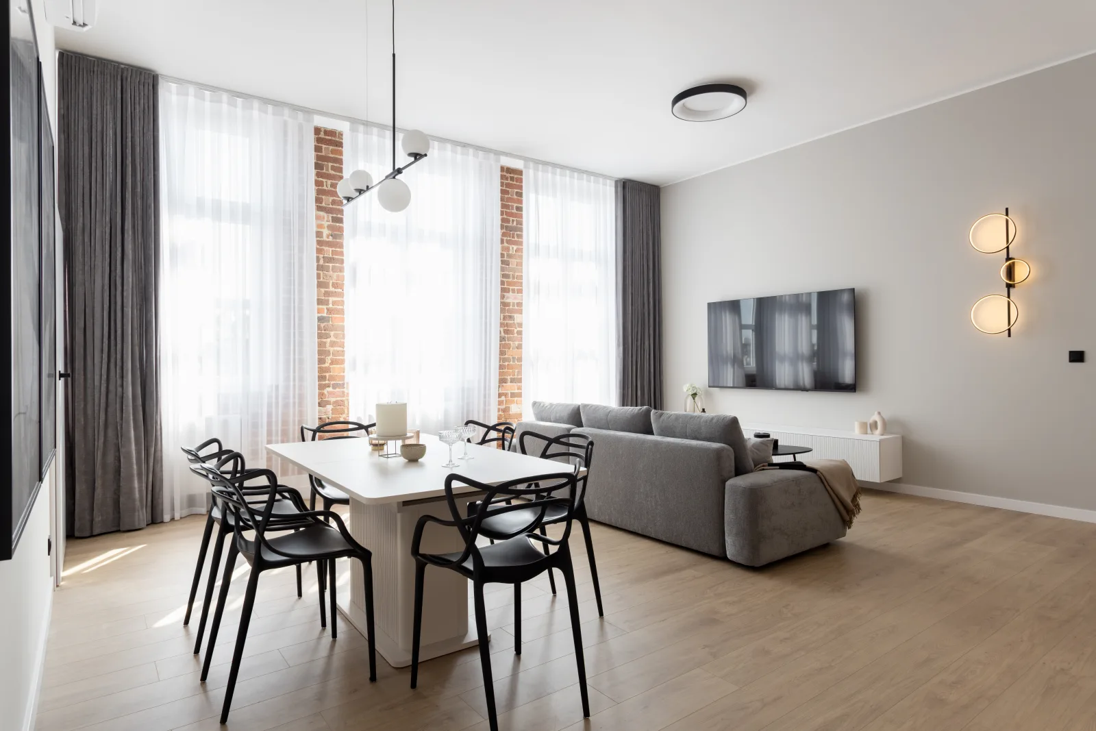 Salon z jadalnią w mieszkaniu w Gliwicach, meble na wymiar Future Wood przy ścianie z cegły