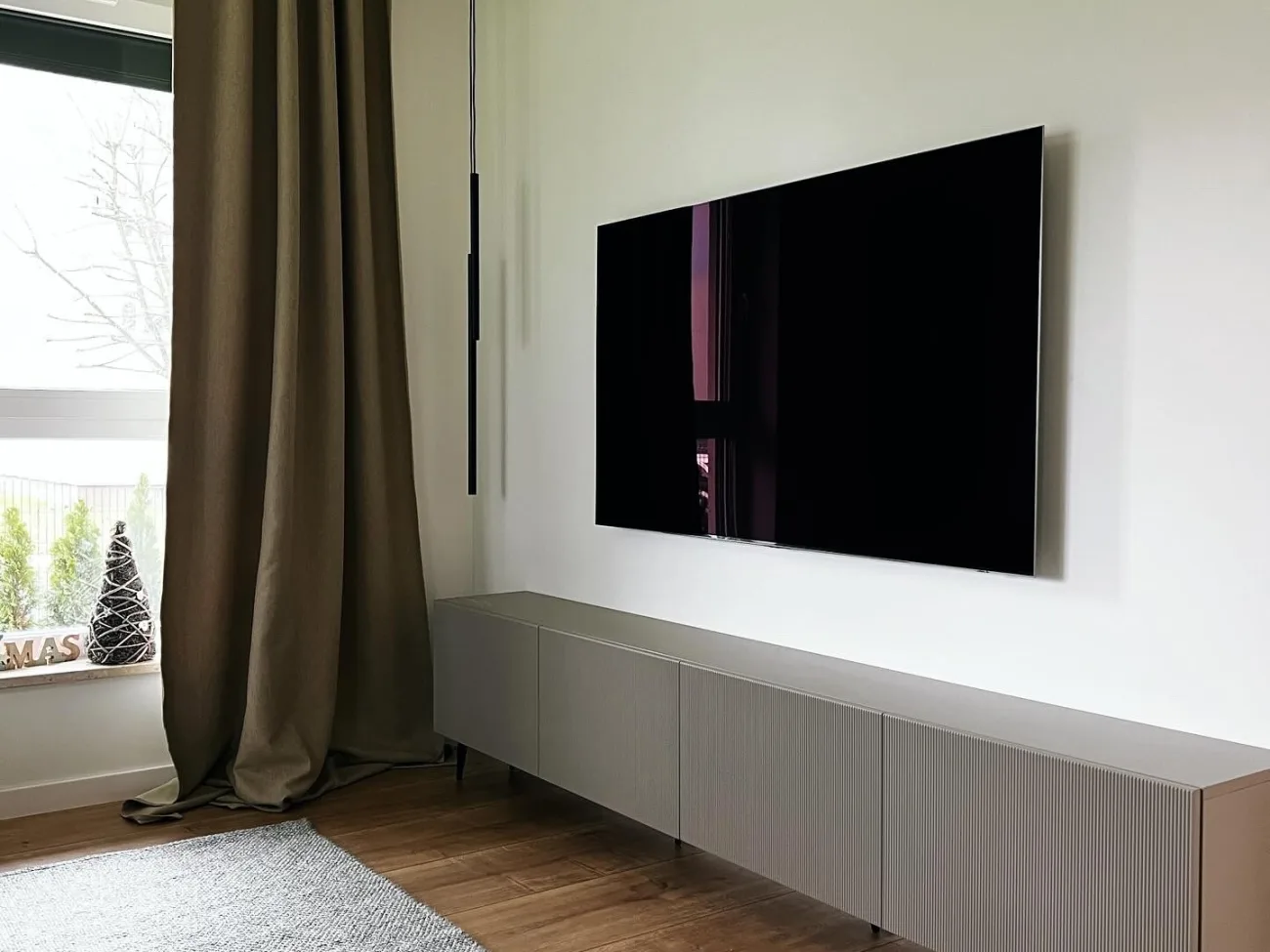 Zabudowa meblowa w salonie z telewizorem i schowanym sprzętem