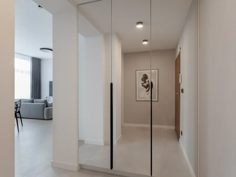 Korytarz z lustrzaną szafą prowadzący do salonu